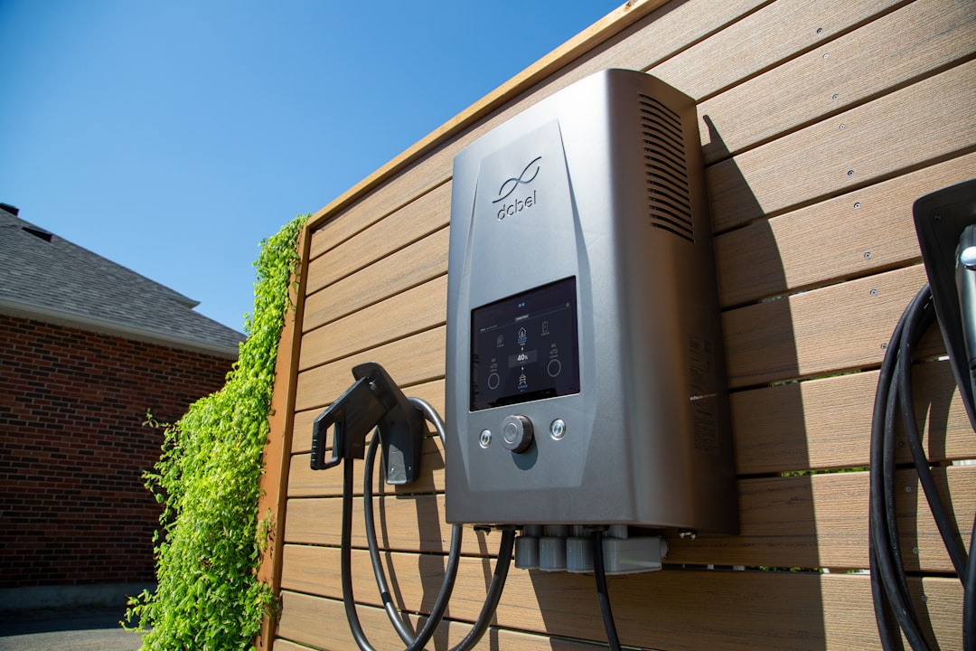 Electric car charger mounted on a wooden wall.