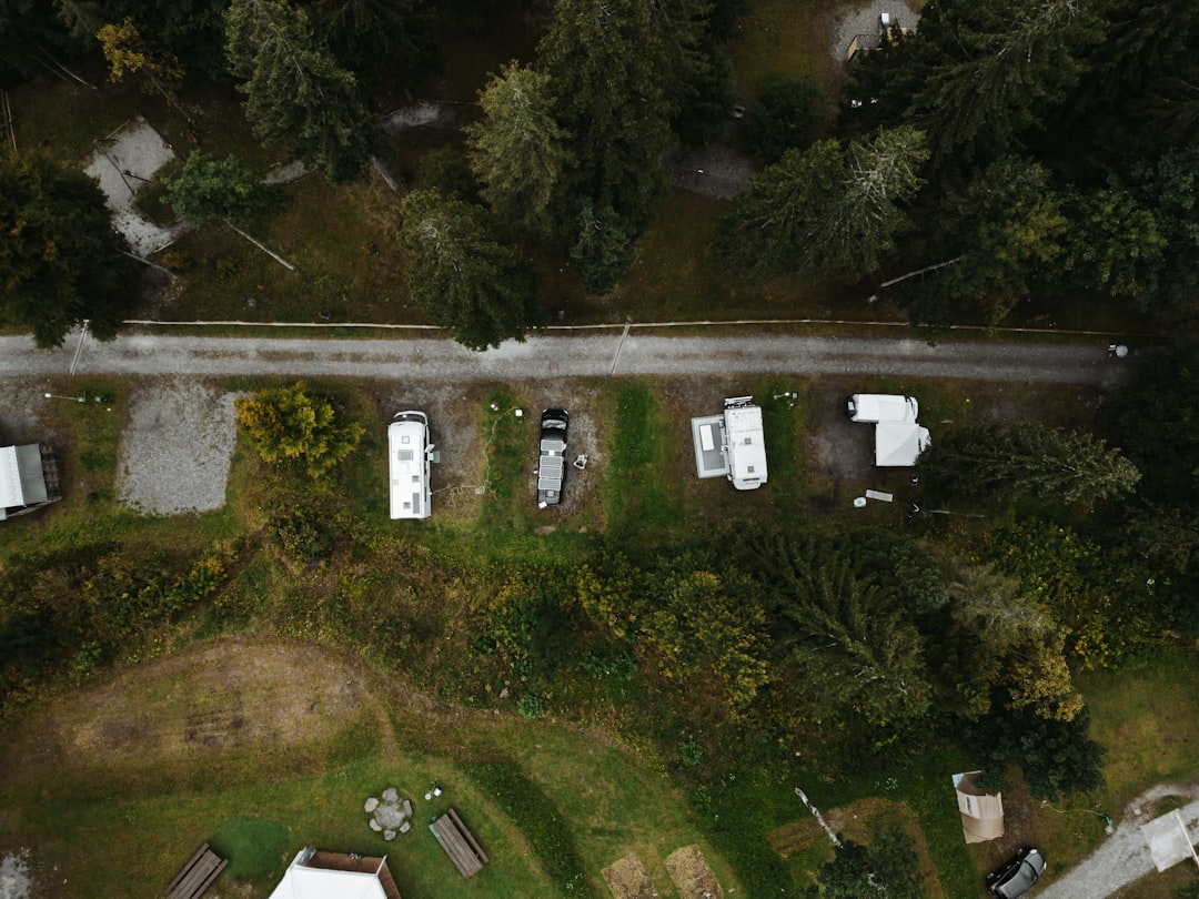 Aerial view of rvs parked along a road near forest