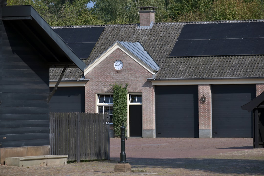 A house with a fence and a clock on the front of it