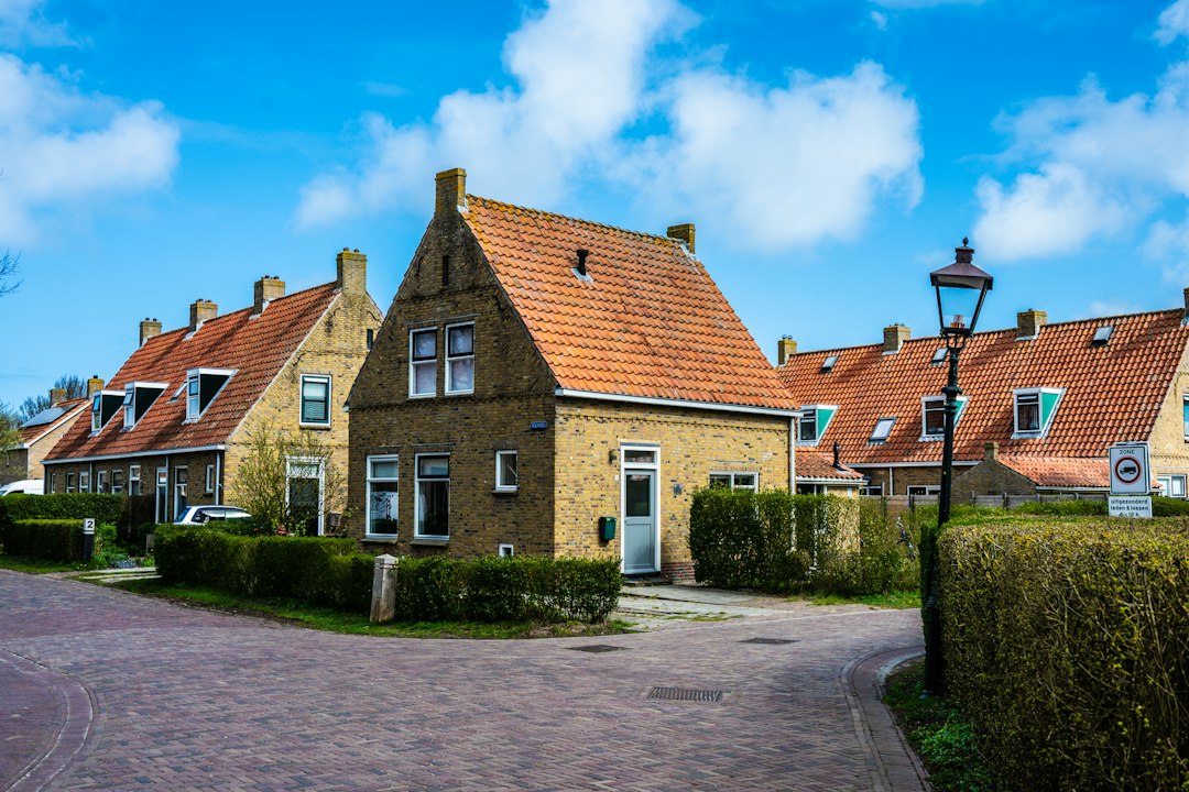 Quaint brick houses with orange roofs and green hedges